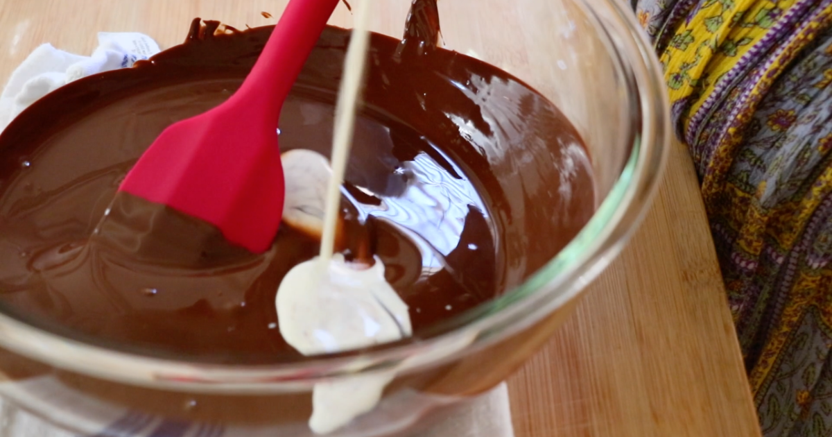 adding heavy cream in melted chocolate to make ganache