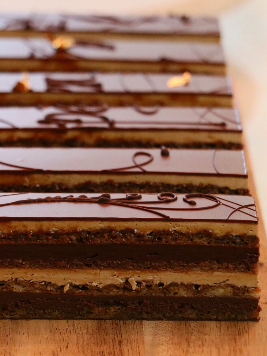 slices of opera cake lined up on a wood board