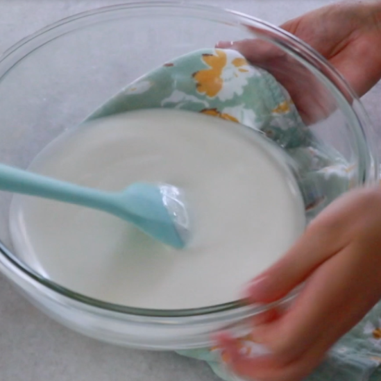 wiping water under the bottom of a bowl of sugar and egg white