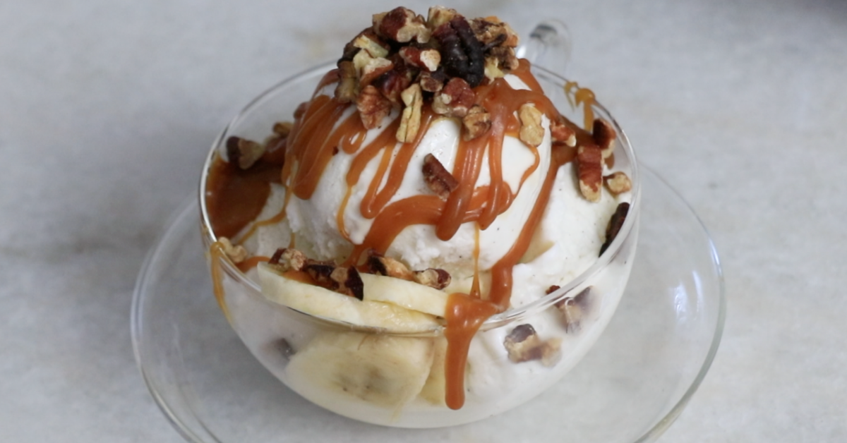 vanilla ice cream with lots of caramel sauce and pecan nuts and slices of banana