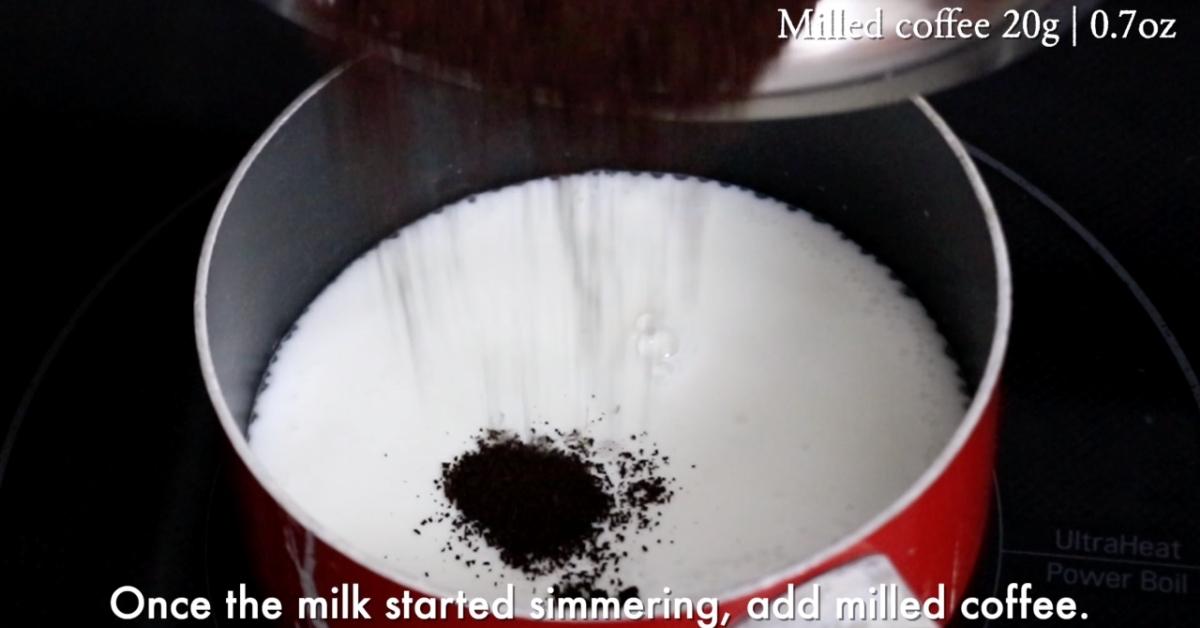adding milled coffee to a hot milk in a pod