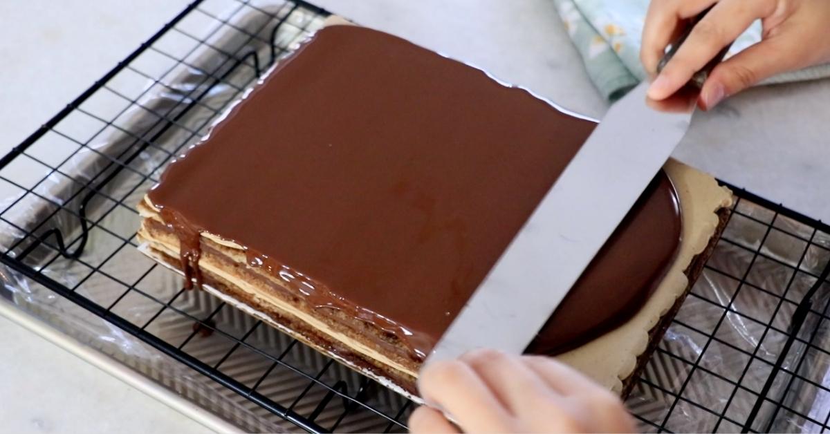 coating chocolate on top of a opera cake