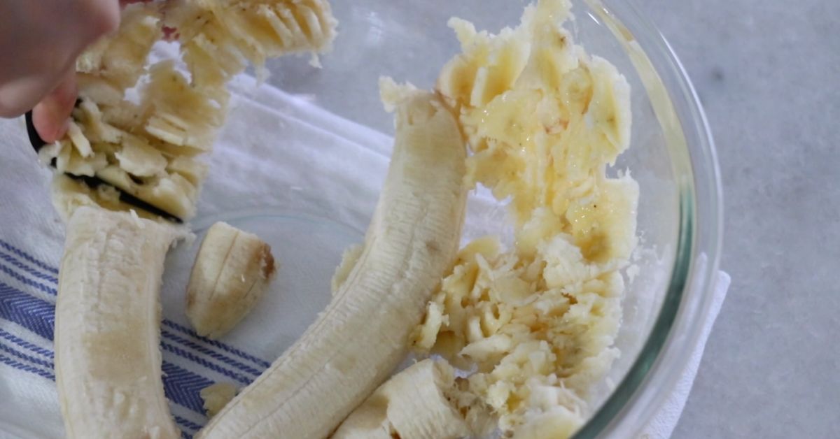 mushing banana in a bowl