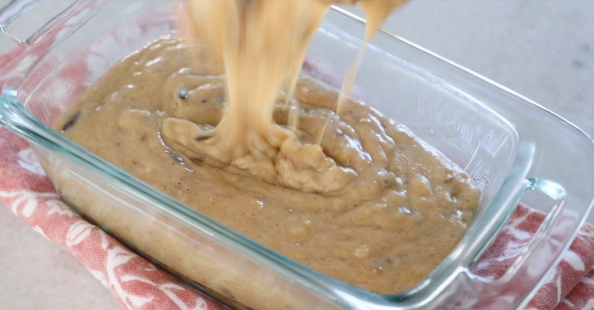 pouring the batter of banana bread into a pan
