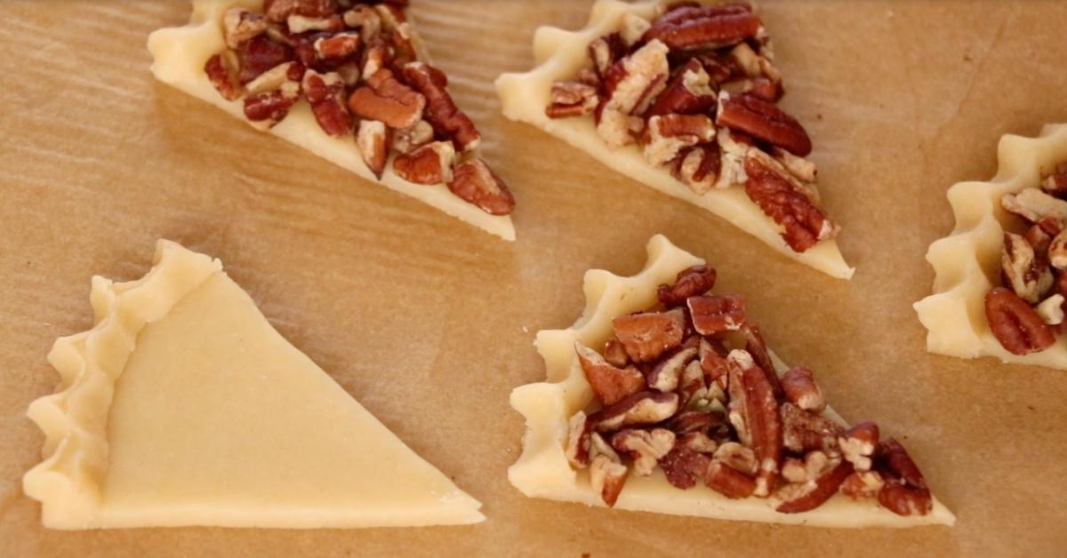 attaching pecans on cookie dough to make pecan pie cookies