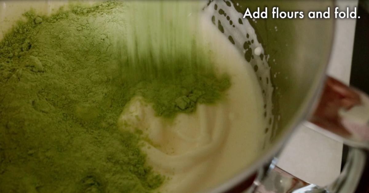 adding matcha and flour in whipped egg and sugar in a bowl