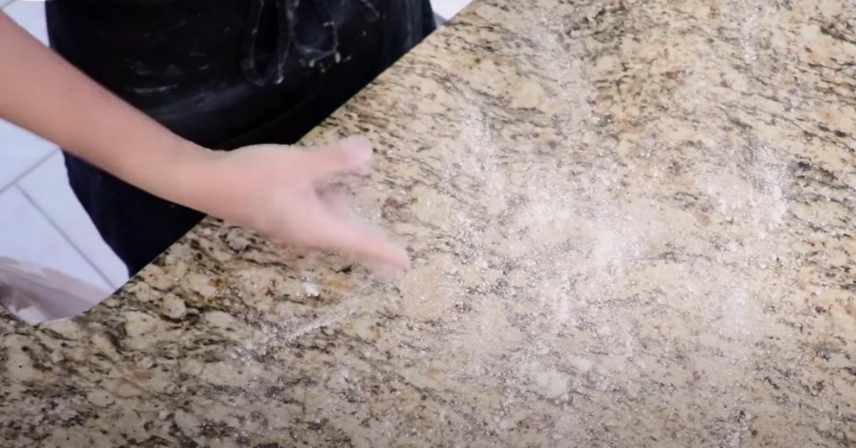 dusting bread flour evenly on a counter