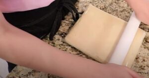 rolling wrapped tart dough into a rectangle shape