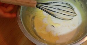 adding milk in yolk mixture to make pastry cream