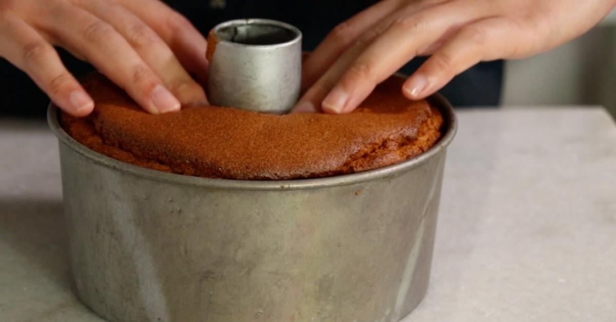 pushing the center of a chiffon cake to remove it from a pan