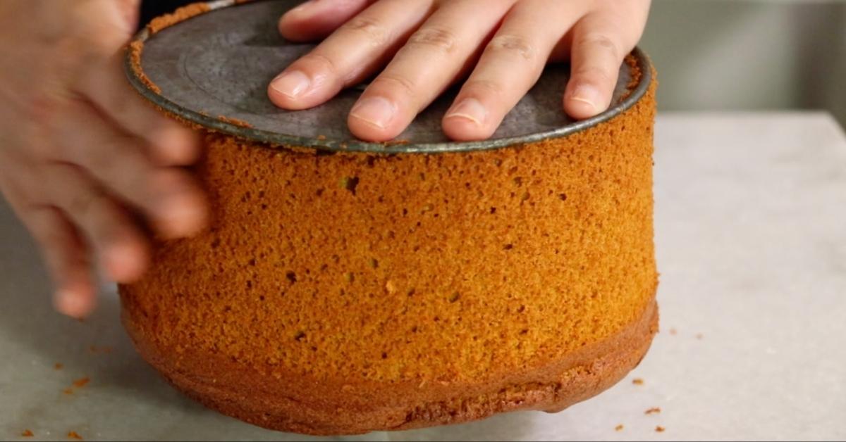 pushing the side of a chiffon cake to remove it from a pan