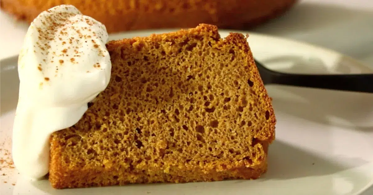 a slice of pumpkin spice chiffon cake with whipped cream on a plate