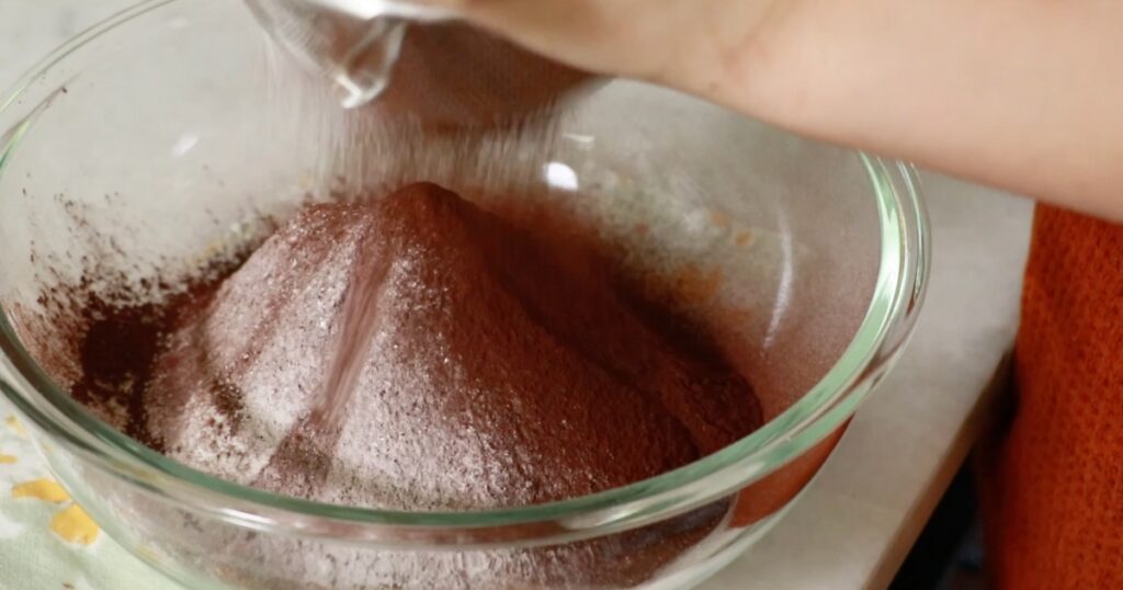 sifting cocoa powder into a bowl
