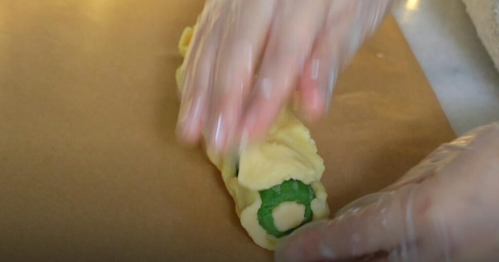 covering green dough with plain dough.