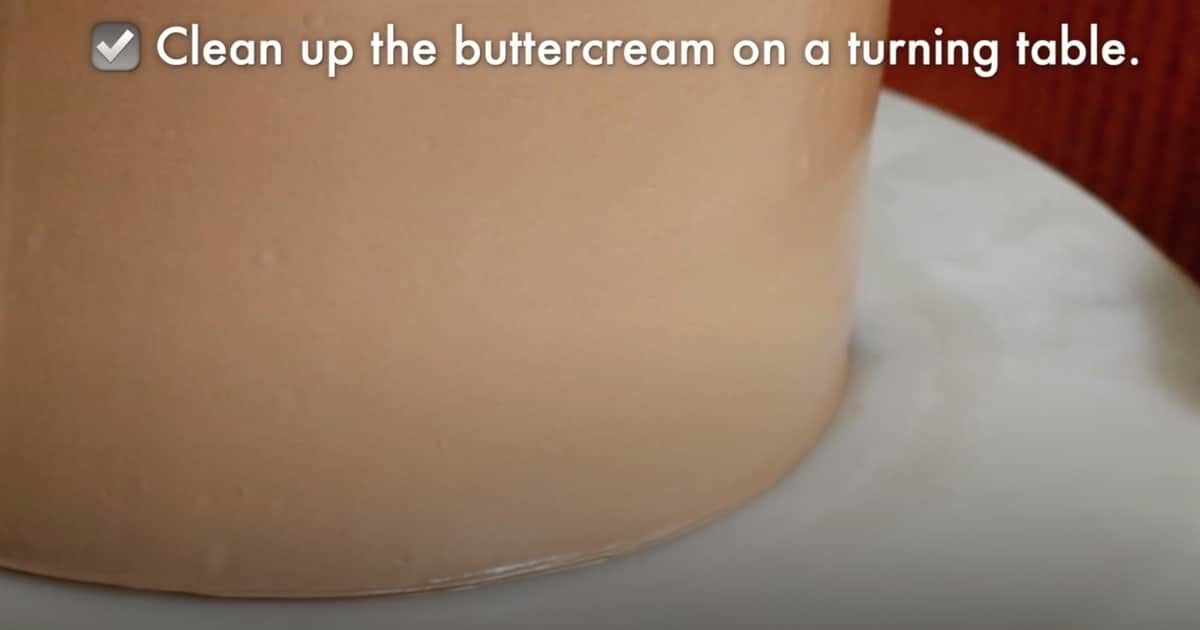 cleaning off buttercream on a turning table