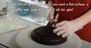 cutting off the uneven surface of a chocolate cake