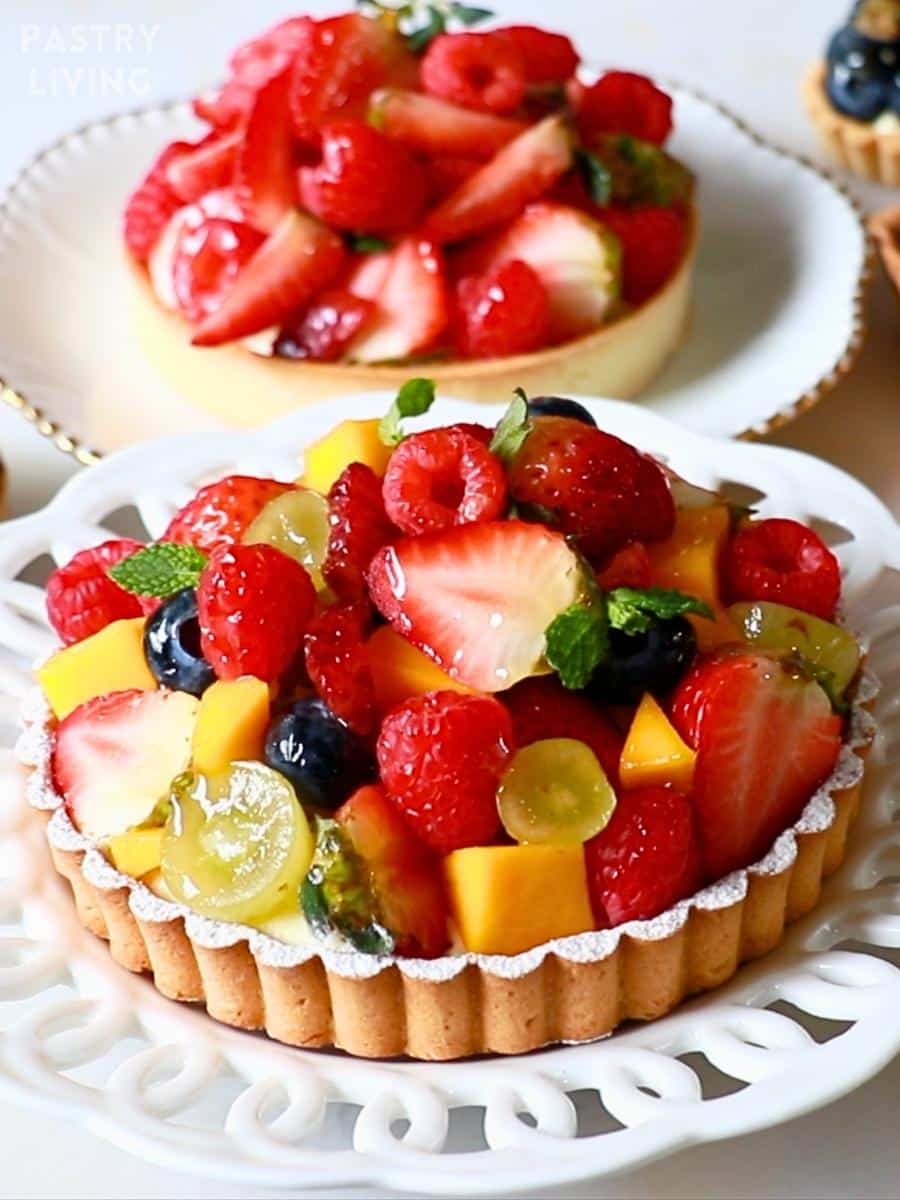 2 round fruit tarts on plates