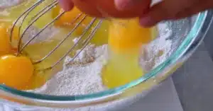 adding egg to sugar, salt and all-purpose flour to make crepes