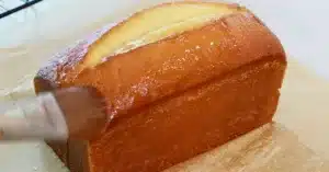 applying lemon syrup on a hot lemon pound cake