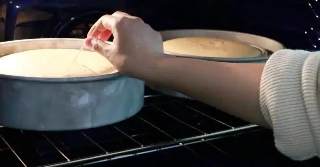 inserting a toothpick into the cake to check if it is baked enough