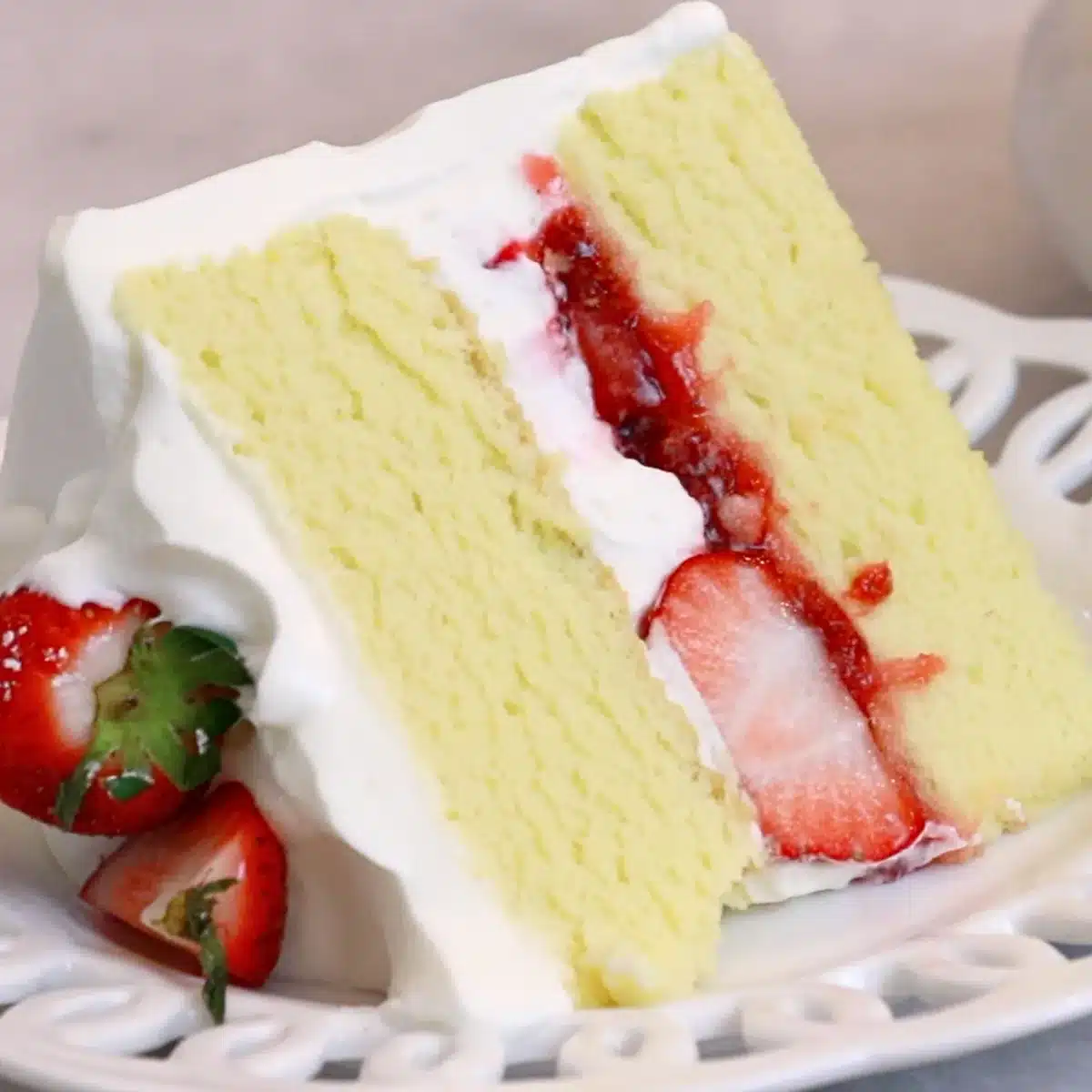 a slice of strawberry cream cake on a white plate