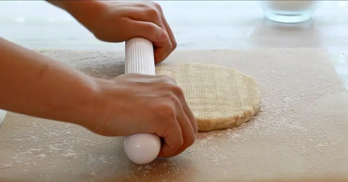 pushing pie dough on parchment paper