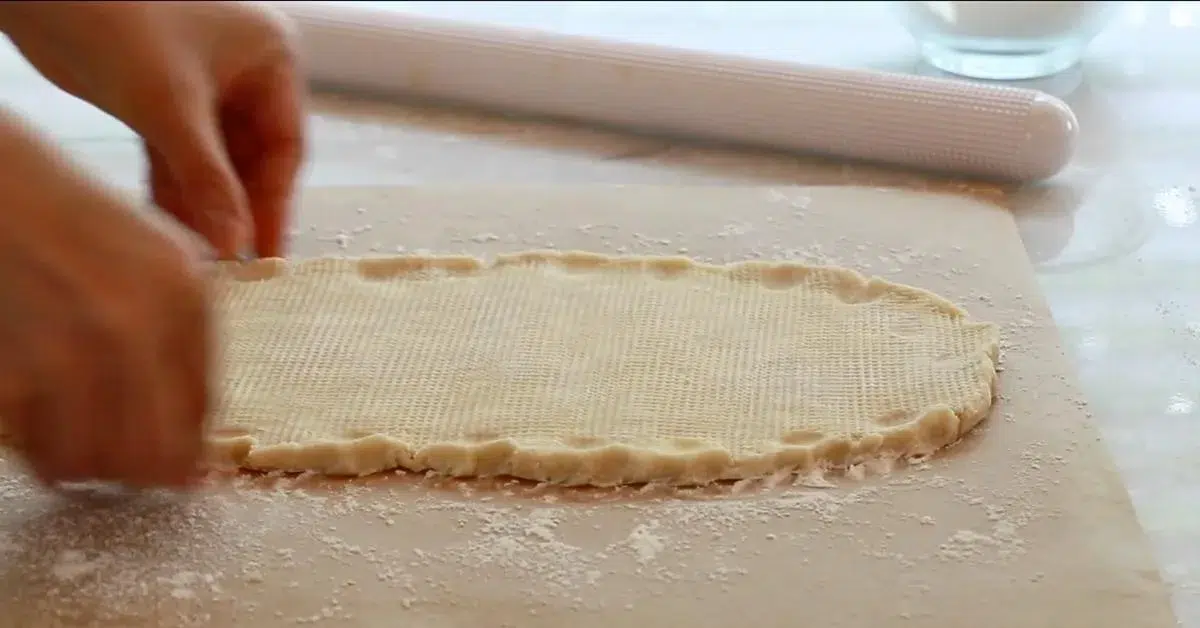 pinching the edge of pie dough on parchment paper