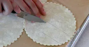 cutting the surface of pie dough with a knife