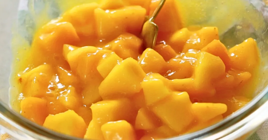 mixing fresh mango and pureed mango in a bowl