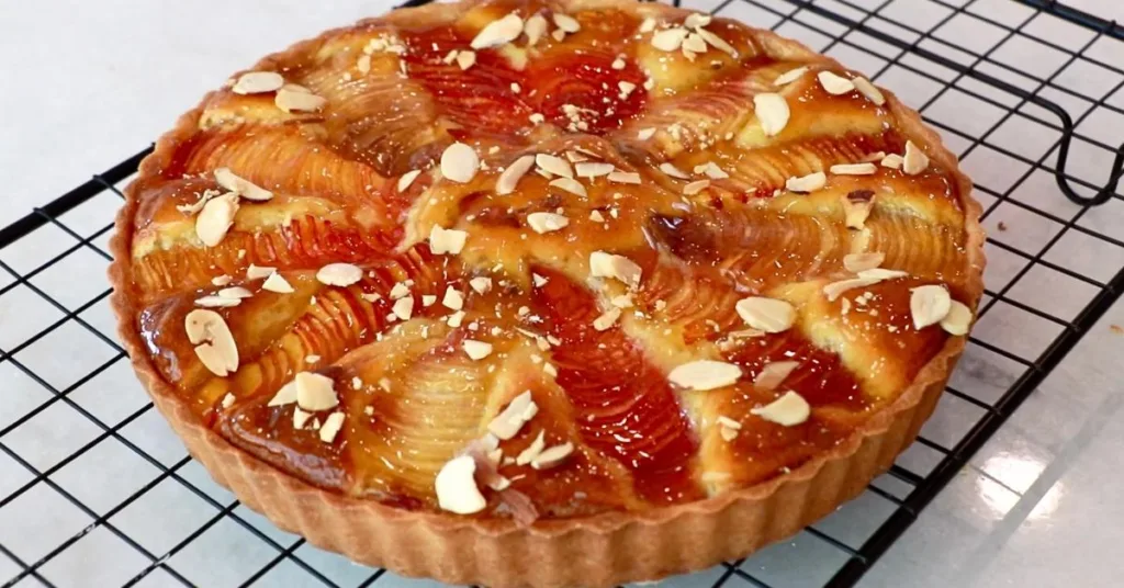 almond peach tart coated with apricot jam glaze and almond slices