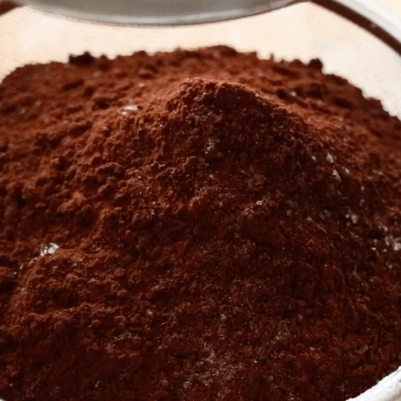 sifting coco powder to make chocolate banana cakes