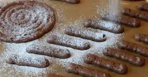 dusting powdered sugar on top of biscuit sponge cake batter