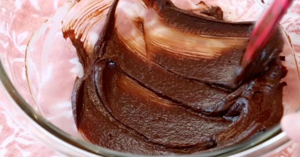 mixed melted dark chocolate, sugar, and heavy cream in a bowl