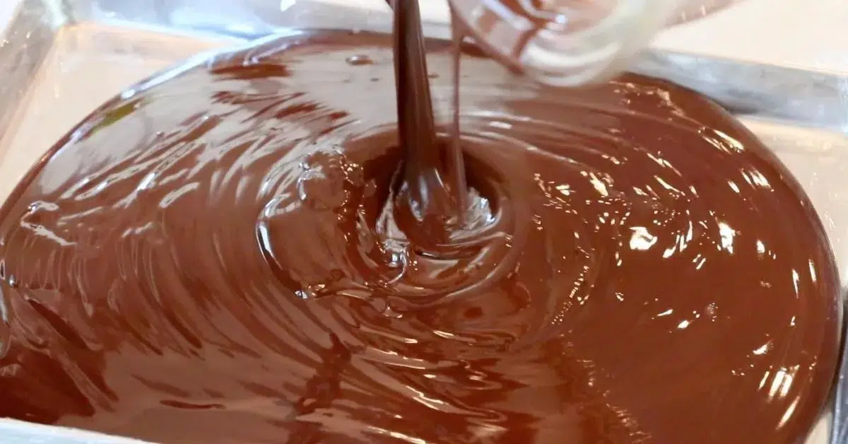 pouring melted chocolate on a tray to make chocolate curls