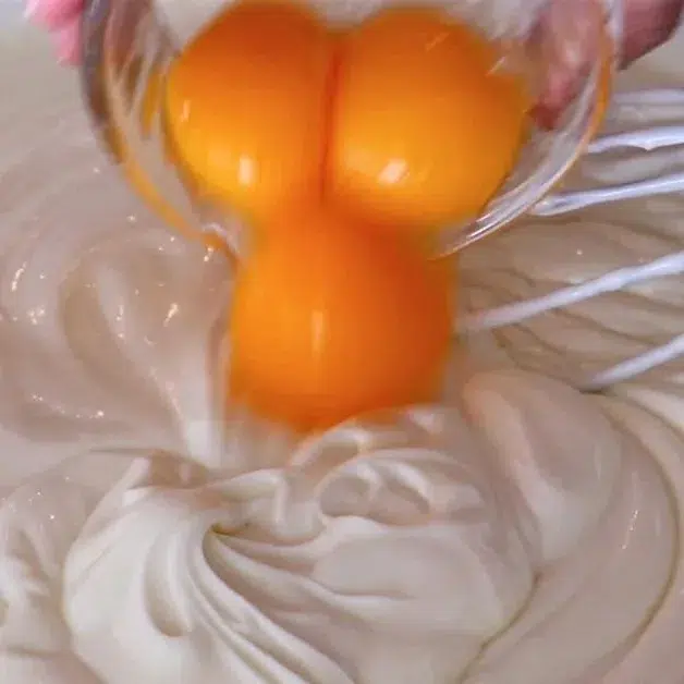 adding yolks to cheesecake batter