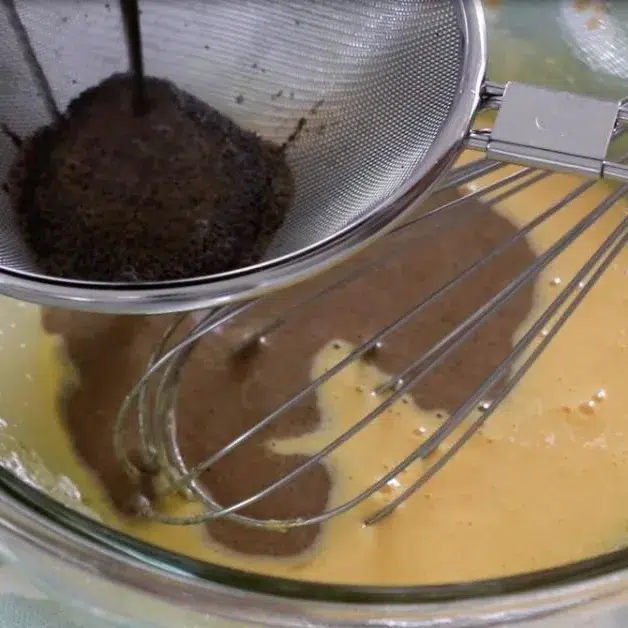 pouring coffee anglaise sauce into egg yolk mixture