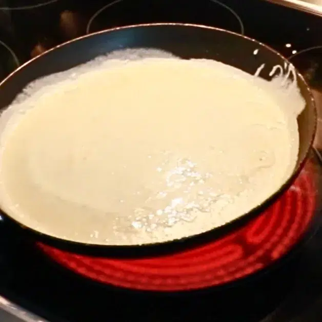 spread crepe batter over a hot pan
