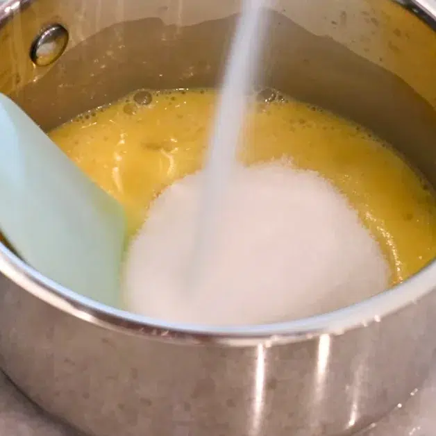adding sugar to eggs to make lemon curd