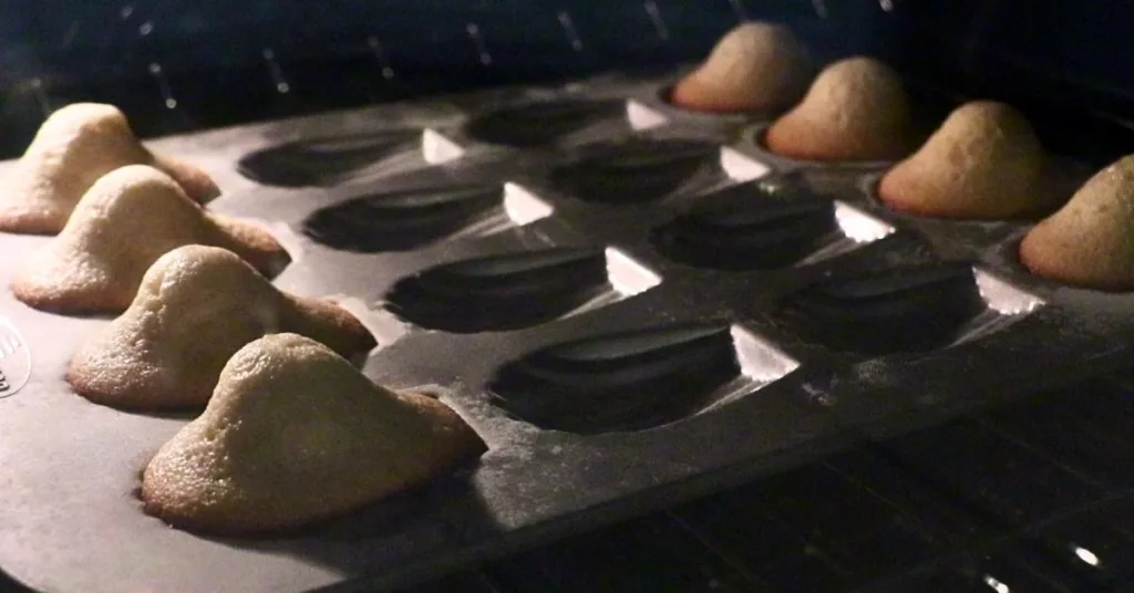 8 madeleines on a pan in the oven