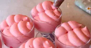 piping raspberry mousse in cups