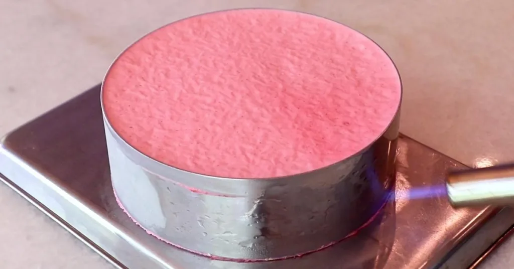 heating a cake ring with a torch to remove it from a cake