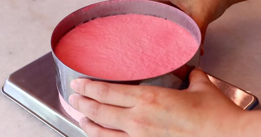 removing a cake ring from a raspberry cake