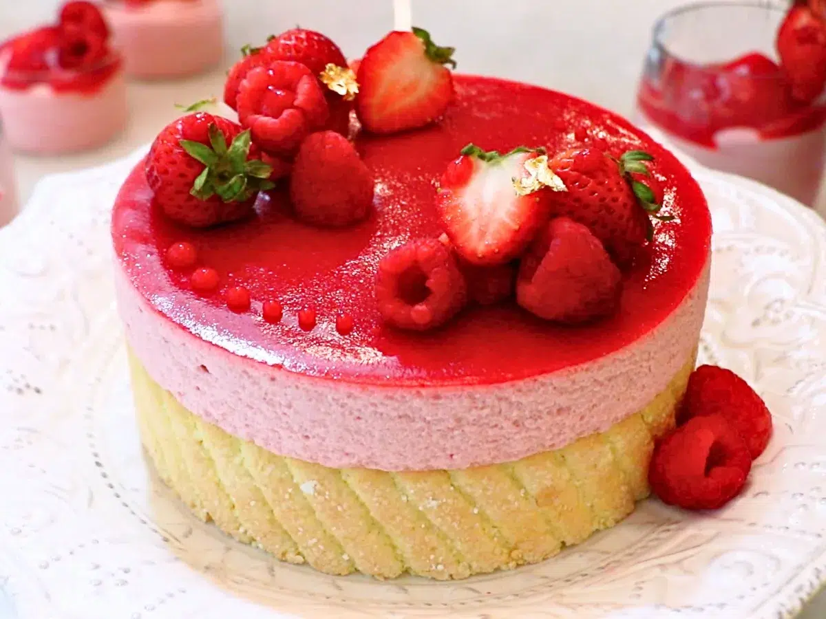 a raspberry mousse cake with fruits on top