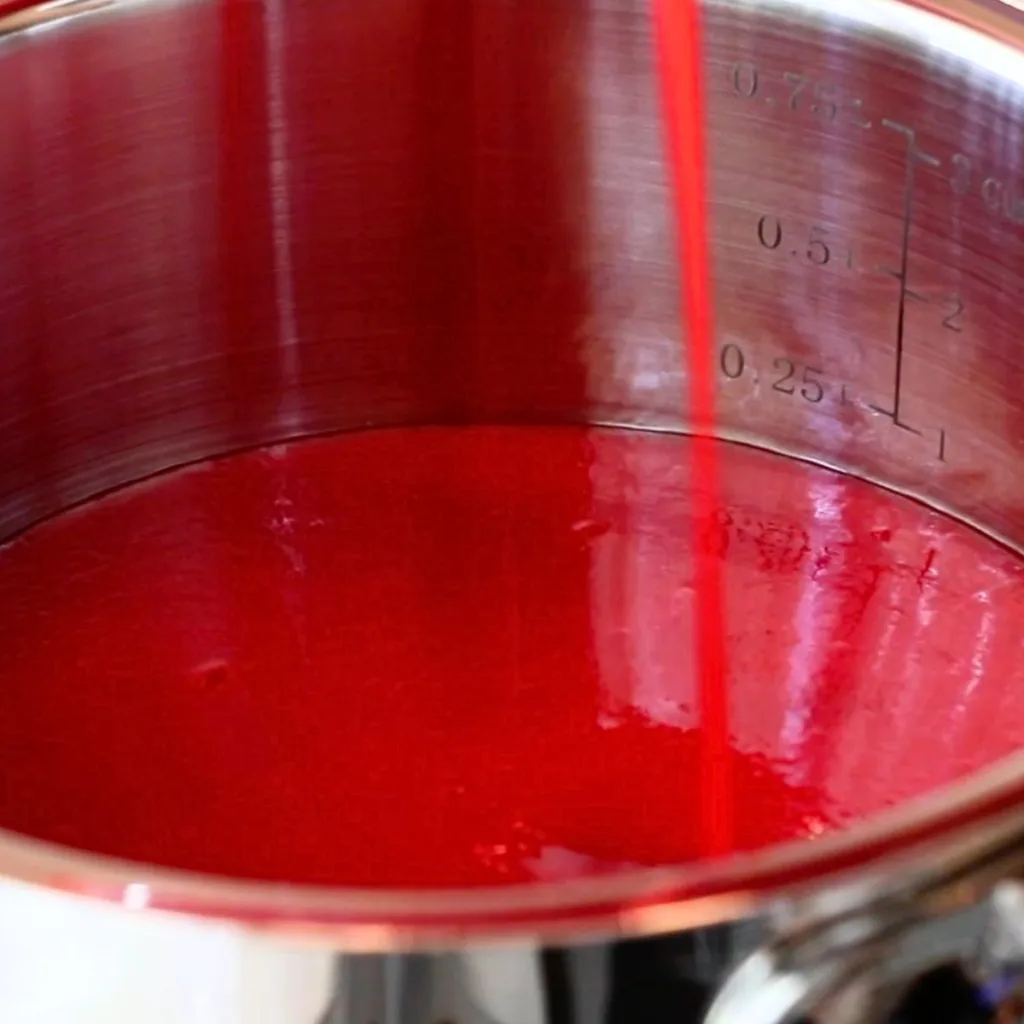 pouring raspberry puree into a pot