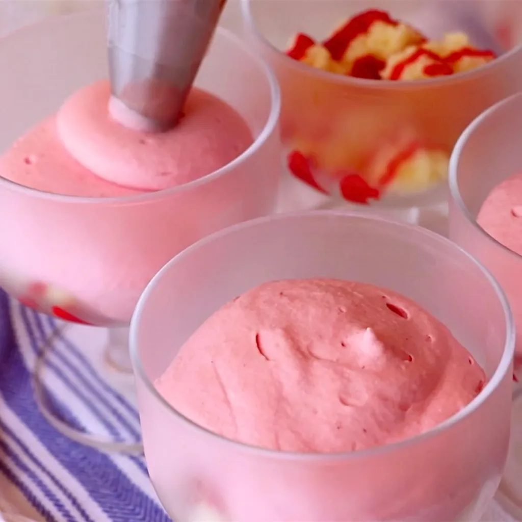 piping fluffy raspberry mousse in glass cups