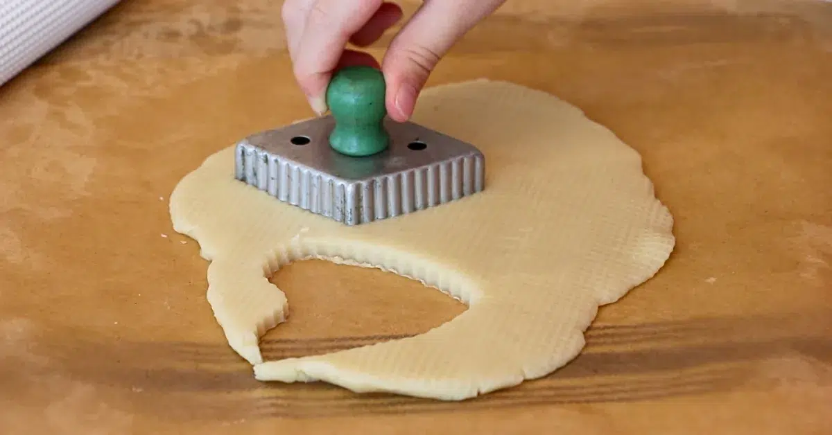cutting cookie dough with a vintage cookie cutter.
