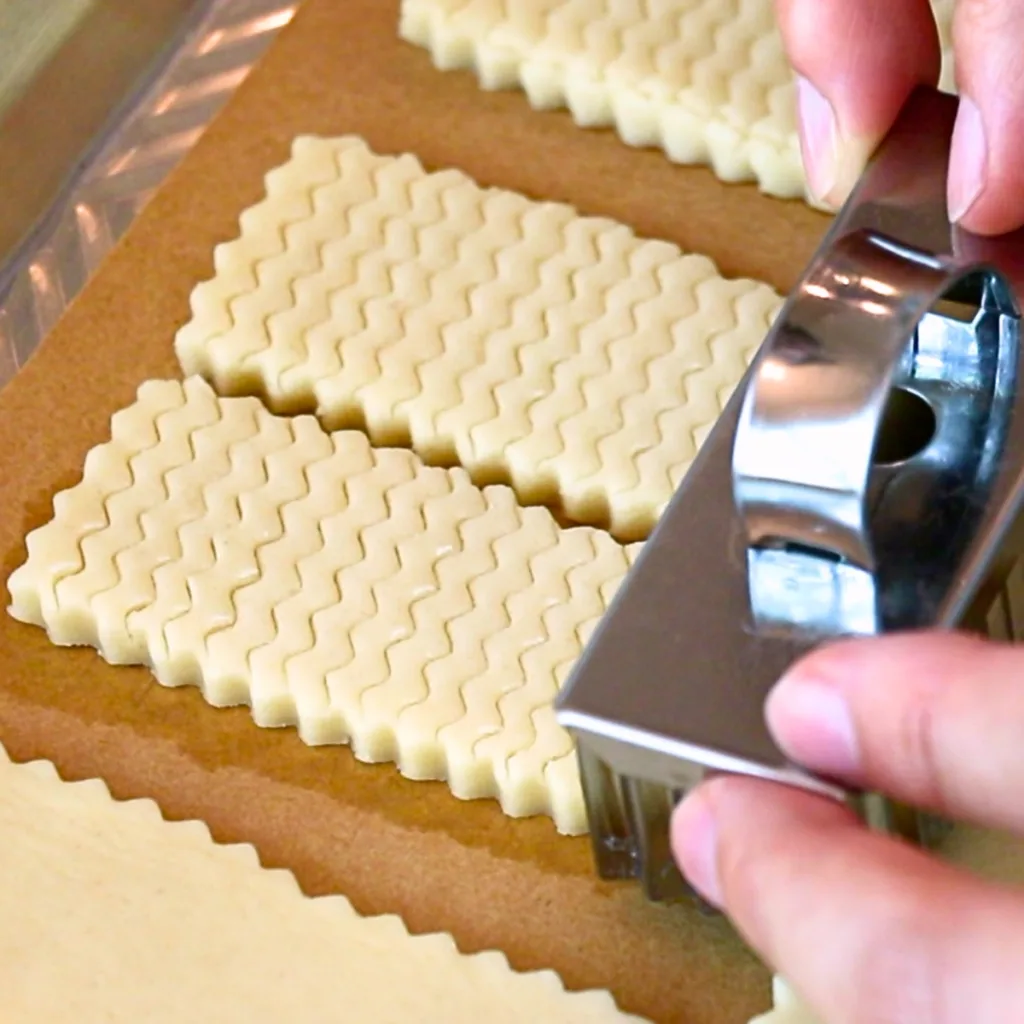 adding pretty patterns on shortbread cookie dough with a cookie cutter.