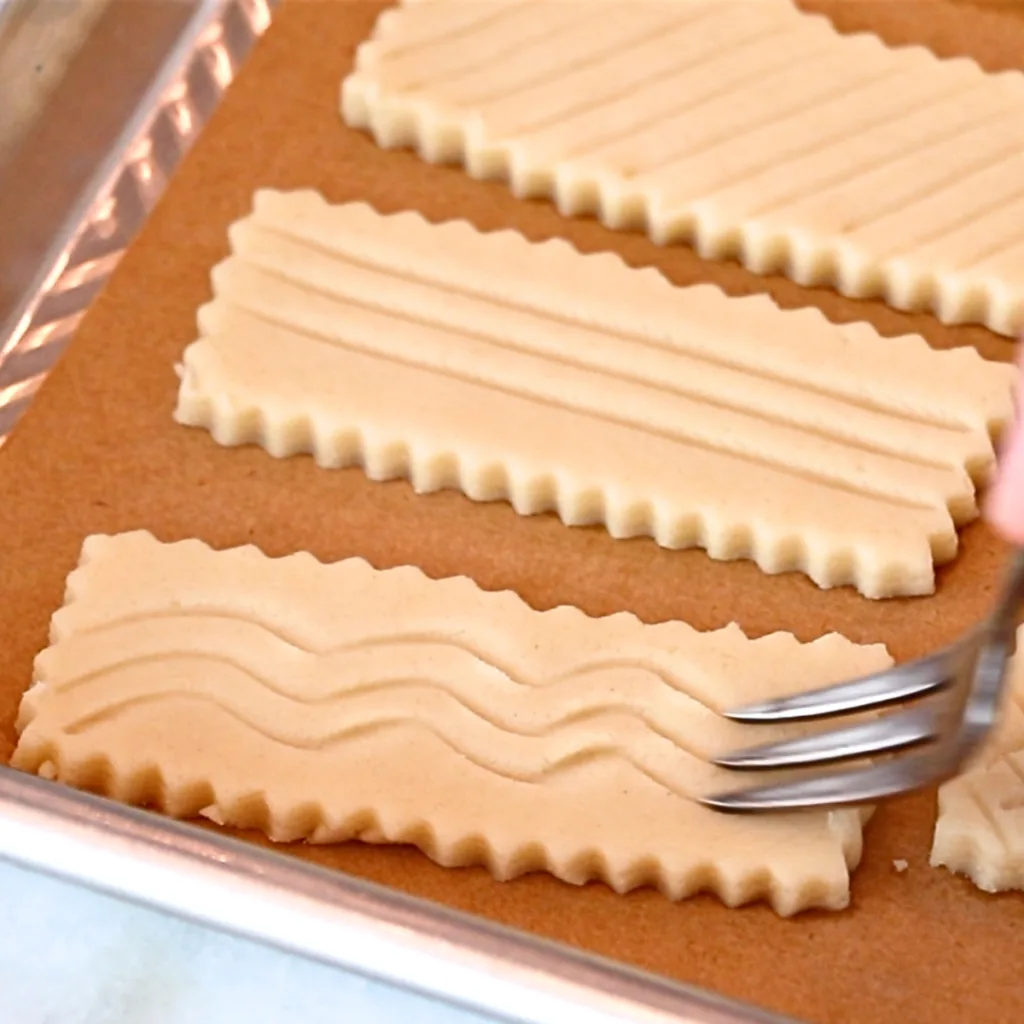 adding wavy lines on shortbread cookie dough with a fork