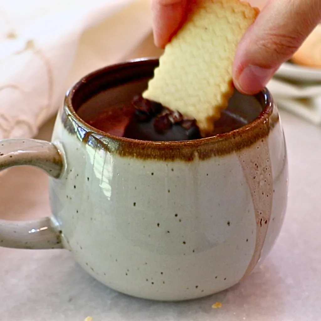 dipping a shortbread cookie in hot coco drink