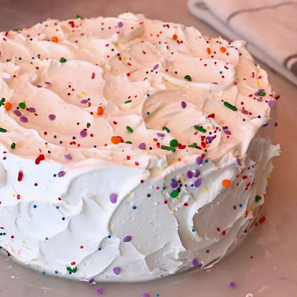 frosted vanilla cake with colorful sprinkles